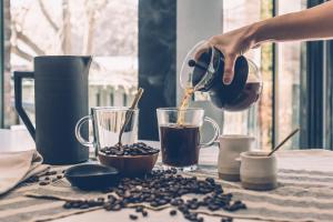 una persona vertiendo café en una taza sobre una mesa en Homevoyage Suites, en Quito