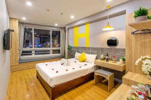 a bedroom with a large bed and a window at Happy Day Riverside Hotel & Spa Danang by Haviland in Danang
