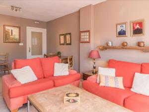 a living room with two red couches and a table at Apartment Las Terrazas by Interhome in Marbella