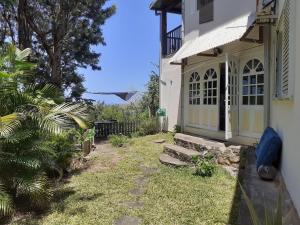 un patio trasero de una casa con un camino que conduce a una puerta en Suite exotique, en Étang-Salé