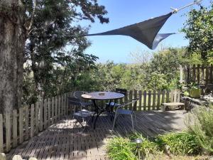 Un patio con una mesa y sillas y una sombrilla. en Suite exotique, en Étang-Salé