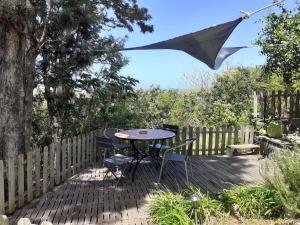 une terrasse avec une table, des chaises et un parasol dans l'établissement Suite exotique, à L'Étang-Salé