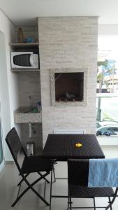 a table and chairs in a kitchen with a fireplace at AP Praia de Palmas in Governador Celso Ramos