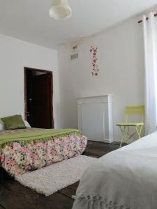 a white bedroom with a bed and a window at Maison de Caractère in Bustanico
