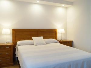 a bedroom with a large white bed with two lamps at Apartment Fontanilla by Interhome in Marbella