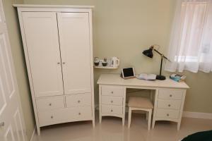 una camera da letto con scrivania e armadietto bianco di The Spinney a Bracknell