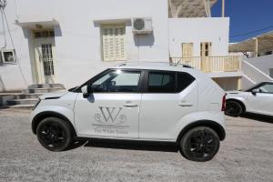 アダマスにあるThe White Suitesの建物前に駐車した白車
