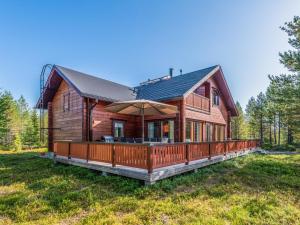 a log cabin with a large deck in the woods at Holiday Home Lapinukonkäännös - incl- 1 ski pass by Interhome in Ruka
