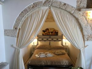 a bedroom with a canopy bed with curtains at Il Trullo dei Sogni in Alberobello