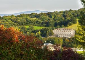 um grande edifício no topo de uma colina com árvores em Hotel Du Golf em Saint-Étienne