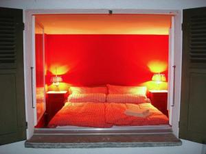 a red bedroom with a bed with two lamps on it at Apartment Pony 2-Bettwohnung by Interhome in Lenk