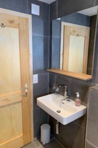 La salle de bains est pourvue d'un lavabo et d'un miroir. dans l'établissement Apartment Butterfly by Interhome, à Adelboden