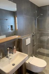 a bathroom with a sink and a shower and a toilet at Apartment Butterfly by Interhome in Adelboden