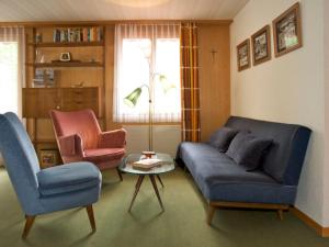 a living room with two chairs and a couch and a table at Apartment Pony 5-Bettwohnung by Interhome in Lenk