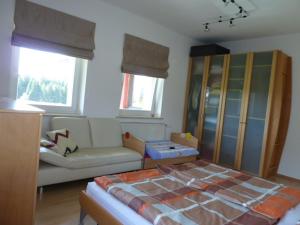 ein Wohnzimmer mit einem Bett und einem Sofa in der Unterkunft Ferienwohnung BEER in Mauth