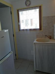 a bathroom with a sink and a window and a tub at Maison de Caractère in Bustanico +12 photos