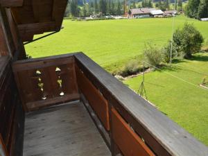 einen Holzbalkon mit Blick auf ein Feld in der Unterkunft Apartment Sonnegg by Interhome in Gsteig