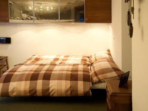 - une chambre avec un lit et une couverture tressée dans l'établissement Apartment Pony 4-Bettwohnung by Interhome, à Lenk im Simmental