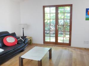 a living room with a black couch and a coffee table at Holiday Home Lac Marion by Interhome in Biarritz