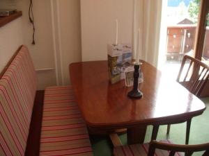 une table à manger en bois avec deux bougies et une chaise dans l'établissement Apartment Pony 4-Bettwohnung by Interhome, à Lenk im Simmental