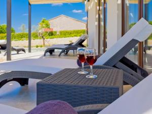 two glasses of wine sitting on a table on a patio at Villa Luna Nera by Interhome in Sveti Petar u Šumi