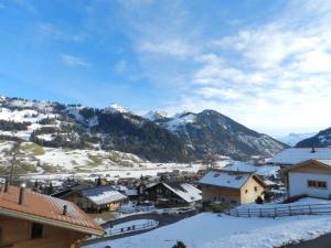 a village covered in snow with mountains in the background at Apartment Gletscherblick- Chalet by Interhome in Zweisimmen