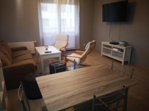 een woonkamer met een bank en een tafel en stoelen bij Apartament Południowy in Radom