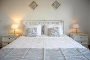 a bedroom with a white bed with two night stands at Traditional House Milos in Pollonia