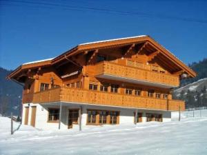 a large wooden building in the snow at Apartment Morgenstern by Interhome in Sankt Stephan