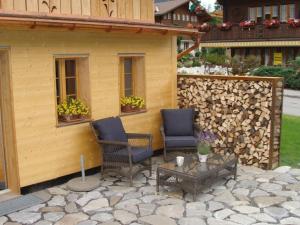 eine Terrasse mit 2 Stühlen, einem Tisch und einem Gebäude in der Unterkunft Apartment Gwunderstübli by Interhome in Lenk im Simmental