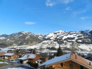 a town with snow covered mountains in the background at Apartment Gletscherblick- Chalet by Interhome in Zweisimmen