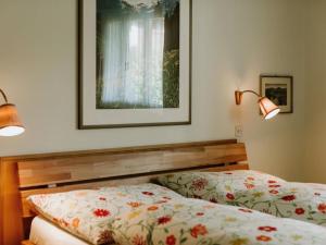 a bedroom with two beds and two lights on the wall at Apartment Bärggeist by Interhome in Adelboden