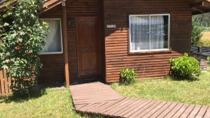 a log cabin with a door and a wooden porch at Cabañas Trabunco in Pucón