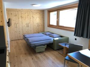 a small room with a bed and a window at Catrina Apartments in Disentis +112 photos