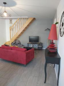 sala de estar con sofá rojo y mesa en La Tanière en Sorcy-Saint-Martin