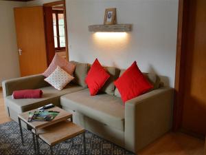 een woonkamer met een bank met kussens erop bij Apartment Oehrli by Interhome in Gstaad