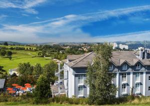a group of houses in a town with a green field at Hotel Du Golf in Saint-Étienne