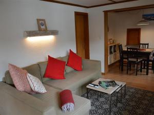 uma sala de estar com um sofá com almofadas vermelhas em Apartment Oehrli by Interhome em Gstaad