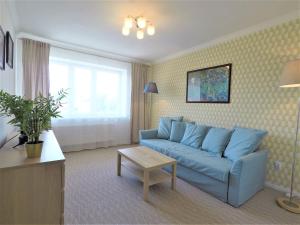 a living room with a blue couch and a table at Apartamenty Dobranoc - Wawer 2 in Warsaw