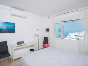 a white bedroom with a bed and a window at Apartment Carmen Vistamar by Interhome in Estepona