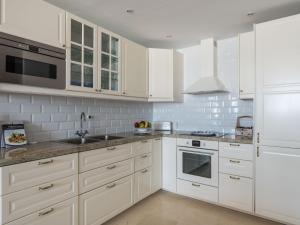 una cocina blanca con armarios blancos y fregadero en Apartment Carmen Vistamar by Interhome, en Estepona