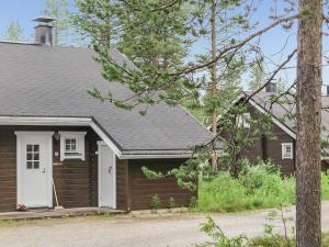 una pequeña casa marrón con una puerta blanca en Holiday Home Kolonen by Interhome en Sirkka