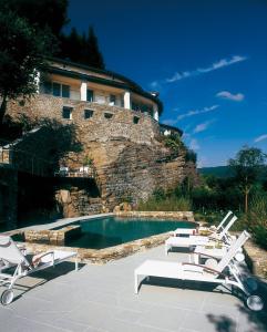 a swimming pool with lounge chairs and a building at Eden Rock Resort in Florence
