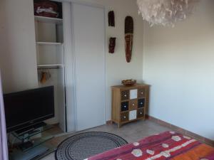 ein Wohnzimmer mit einem Flachbild-TV und einem Schrank in der Unterkunft logement zen sur la colline aux mimosas in Hyères