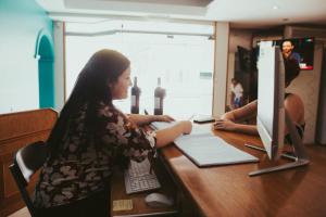 two women sitting at a desk with a computer at San Rafael Group Hotel in San Rafael