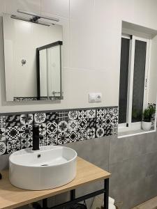 y baño con lavabo blanco y espejo. en Nova Domus Apartamentos en Mérida