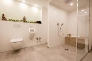 a white bathroom with a shower and a toilet at Bliesransbacher 8 in Saarbrücken