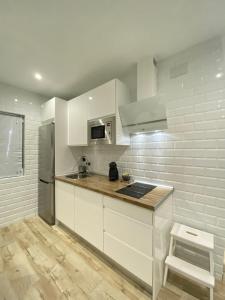 a kitchen with white cabinets and a counter top at Nova Domus Apartamentos in Mérida