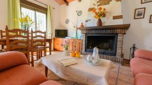 sala de estar con mesa y chimenea en Casa Rural El Moral, en Málaga
