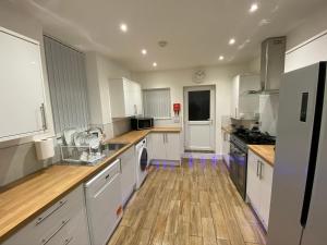 cocina grande con armarios blancos y suelo de madera en Heaton Park Road Professional Lets, en Newcastle 27 fotos más